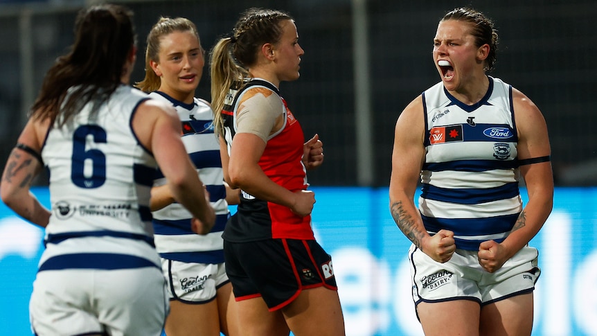 A Geelong AFLW player pumps her fists as she celebrates a goal against St Kilda.