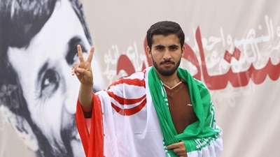 An Iranian youth, with a national flag on his shoulders (Getty Images: Amir Hesami)