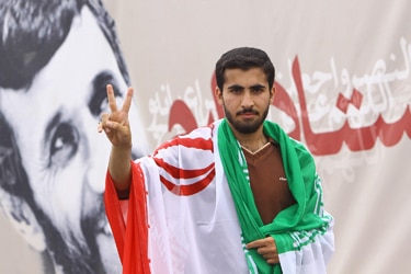 An Iranian youth, with a national flag on his shoulders (Getty Images: Amir Hesami)