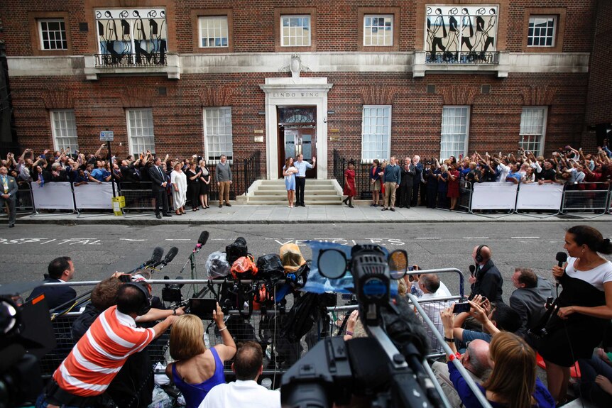 A huge media pack surrounds Kate and William as they cradle their baby George