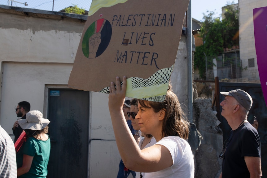 An activist takes part in a protest with a sign which reads: Palestinian Lives Matter 