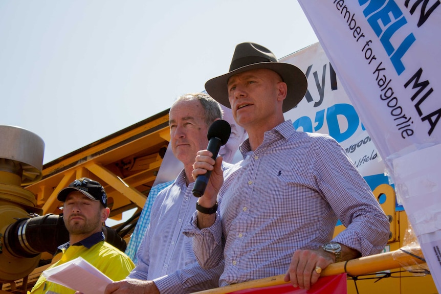 Two Liberal MPs speak from the back of a drill rig.