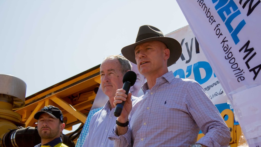 Two Liberal MPs speak from the back of a drill rig.