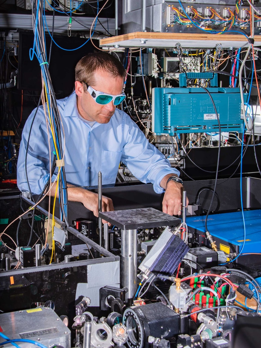 A man working in a lab surrounded by wires