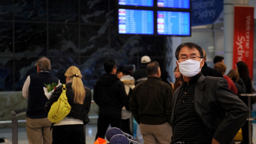 A man wearing a face mask arrives at Sydney Airport