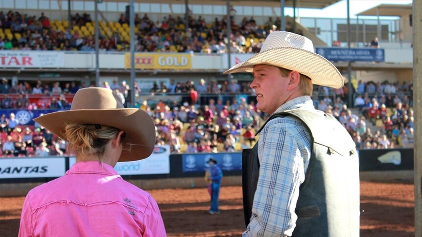A bull rider anxiously watches the action from behind his chute as he prepares for his event at the Mt Isa Rodeo