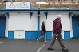 People walk past a jewellery shop with its shutters closed in Wales.