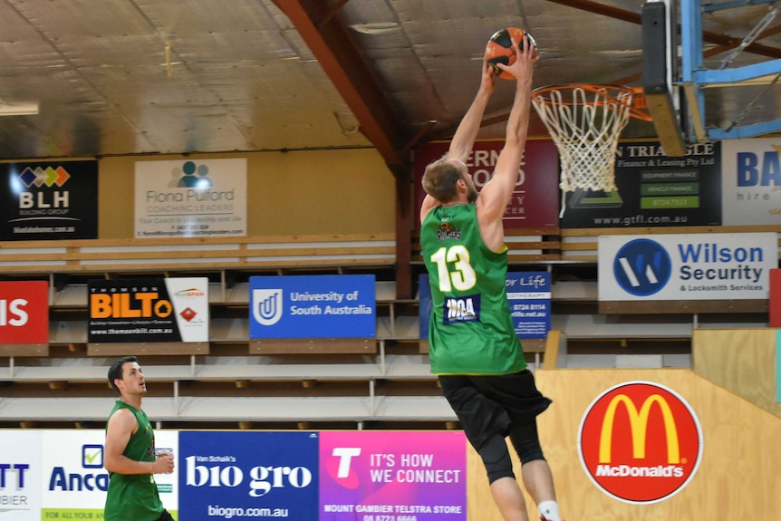 A basketball player goes for a slam dunk during a training session