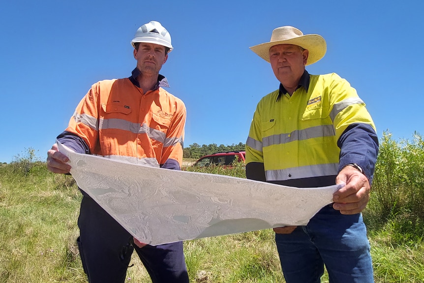 men looking and holding map