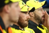 The camera focuses on Australian captain, Aaron Finch, sitting among players watching a World Cup match.