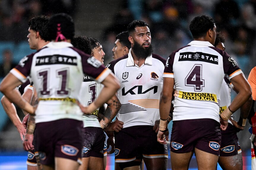 Payne Haas looks dejected, surrounded by teammates, after the Brisbane Broncos concede a try