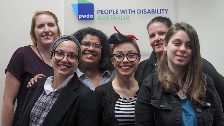 Six women standing out the front of the People with Disability Australia sign.