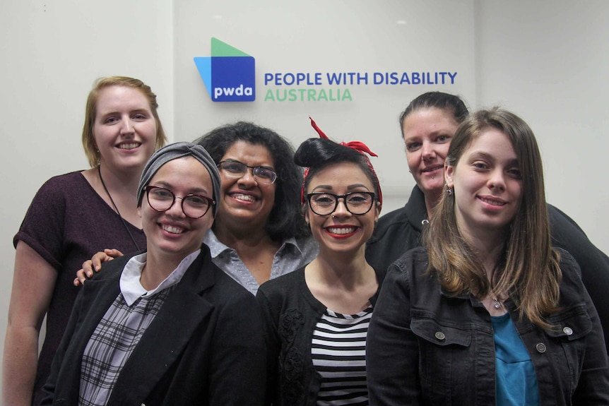 Six women standing out the front of the People with Disability Australia sign.