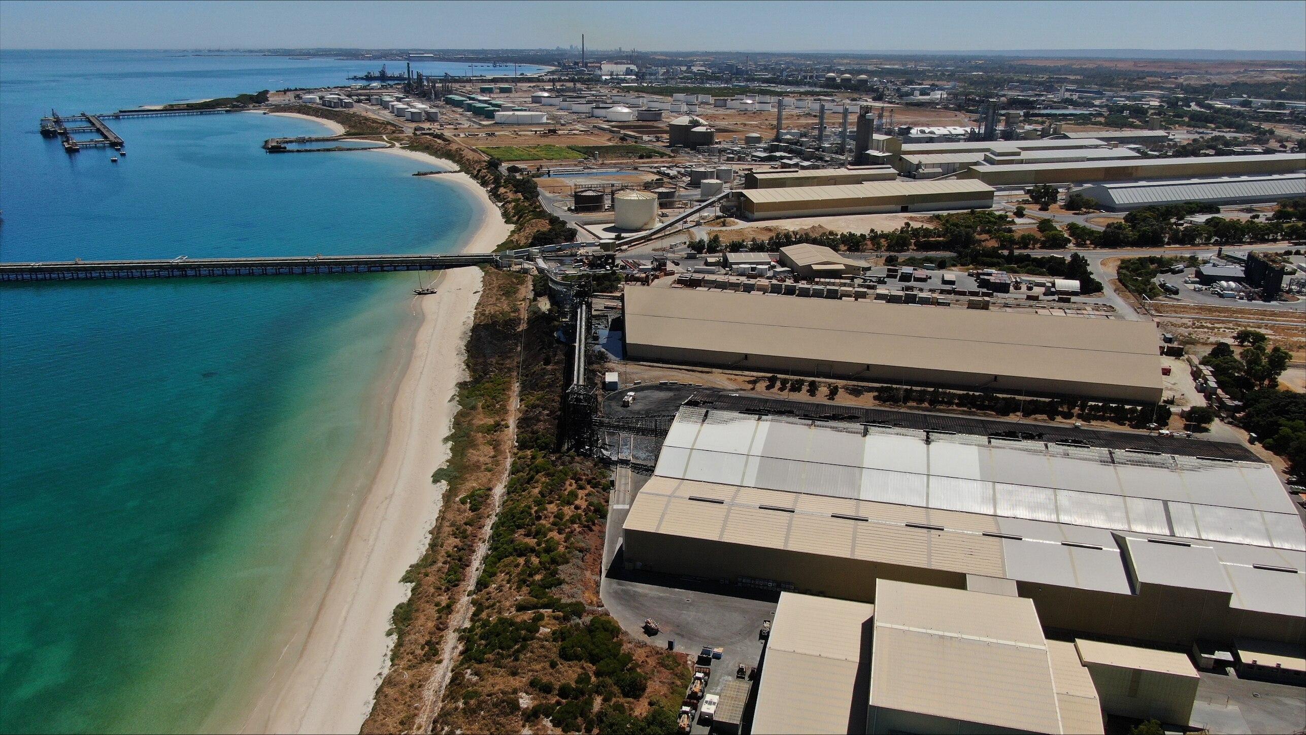 An aerial image showing fire damage to a storage factory near a beach