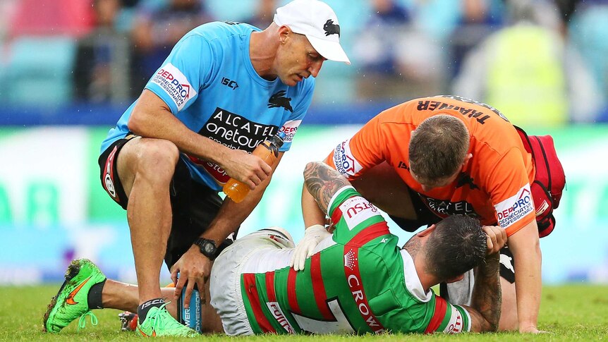 South Sydney's Adam Reynolds receives attention after injuring his knee against Canterbury.