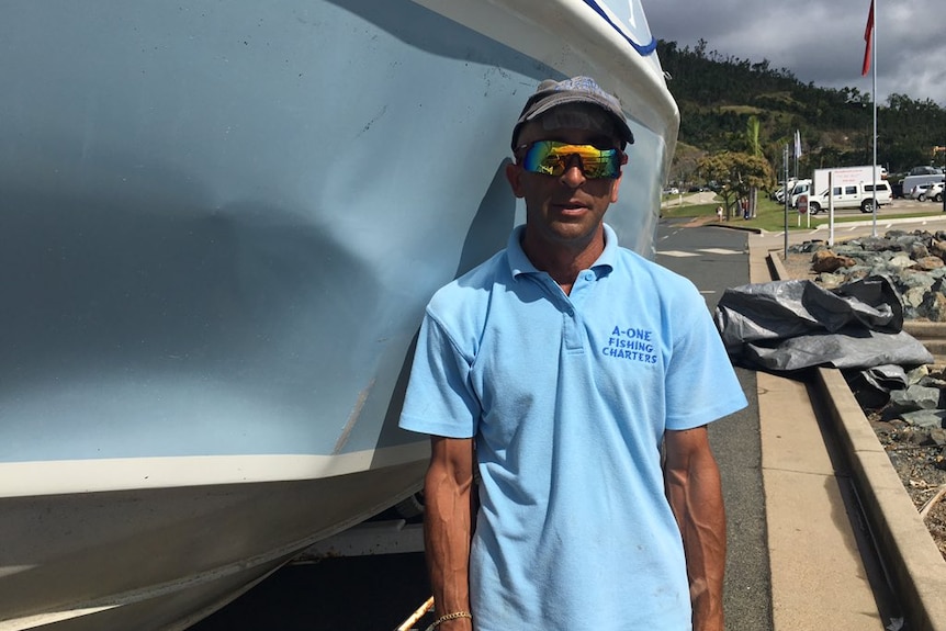 Skipper Oliver Galea, stands besides the boat that was damaged after colliding with a humpback whale.