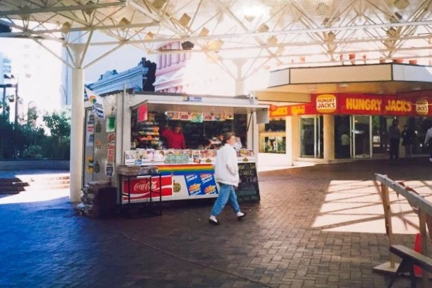 Small newsagency kiosk outside hamburger shop