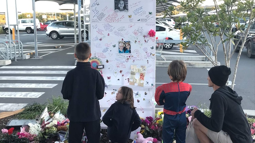 Young children looking at memorial of 6yo girl Indie Armstrong