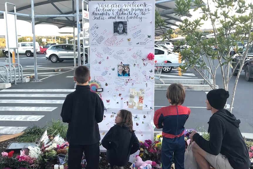 Young children looking at memorial of 6yo girl Indie Armstrong