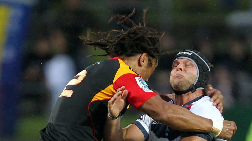 Tough encounter ... Jarrod Saffy is hit hard in a tackle from Tana Umaga