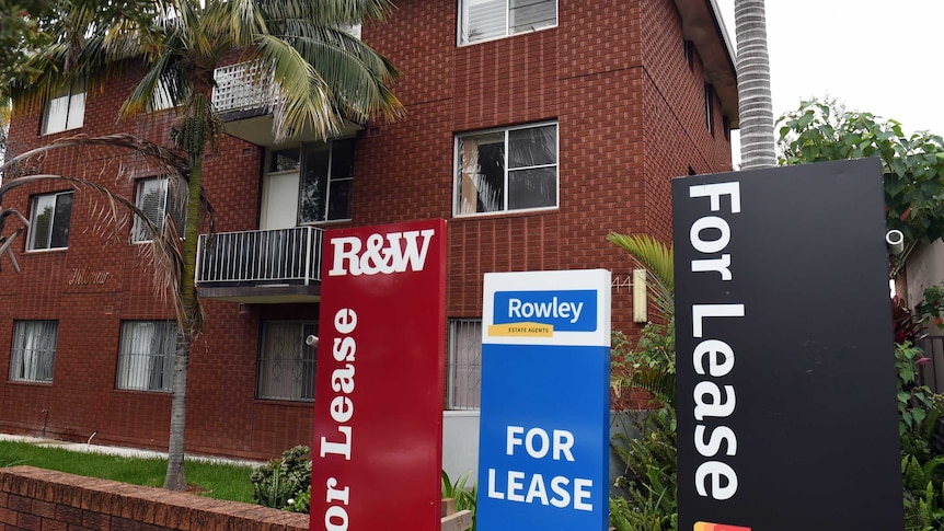 'For lease' signs outside an apartment building.