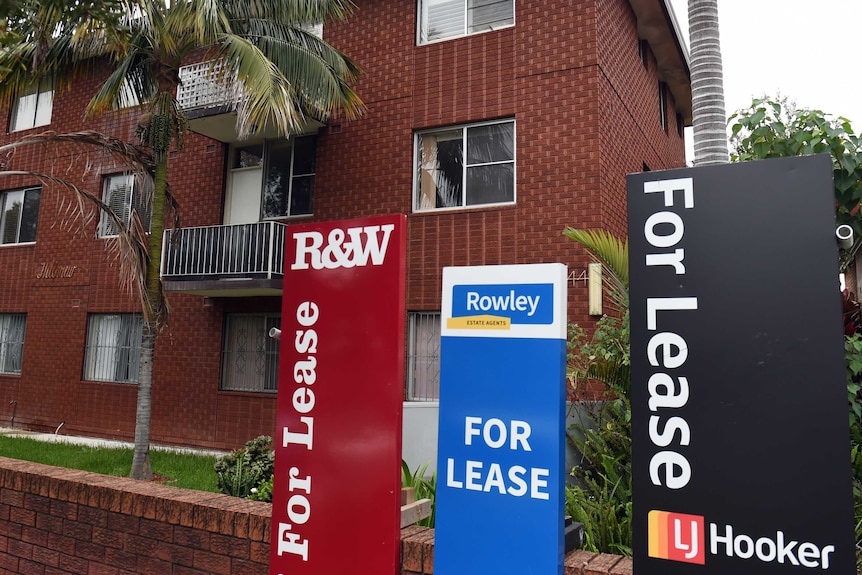 'For lease' signs outside an apartment building.