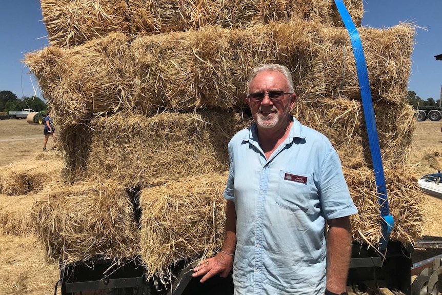 David Checker standing in front of hay bales