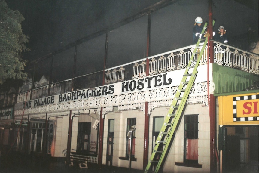 Firefighters work on the building following the fatal fire in 2000
