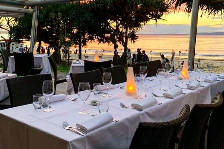 An empty waterfront restaurant table at dusk