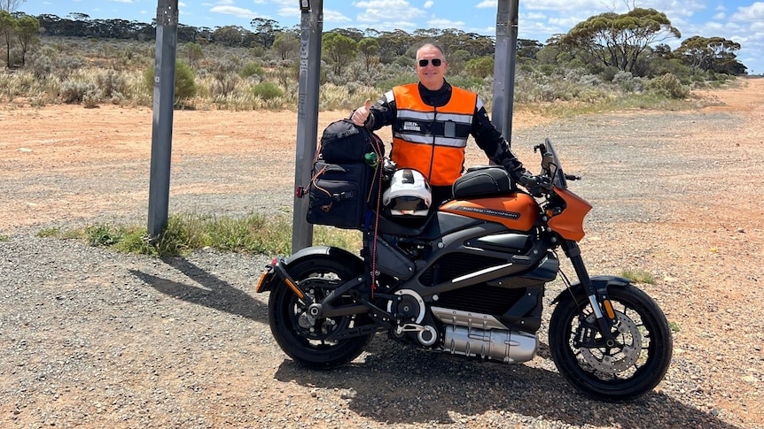 Ed Darmanin poses with his electric Harley Davidson and the iconic Nullarbor sign