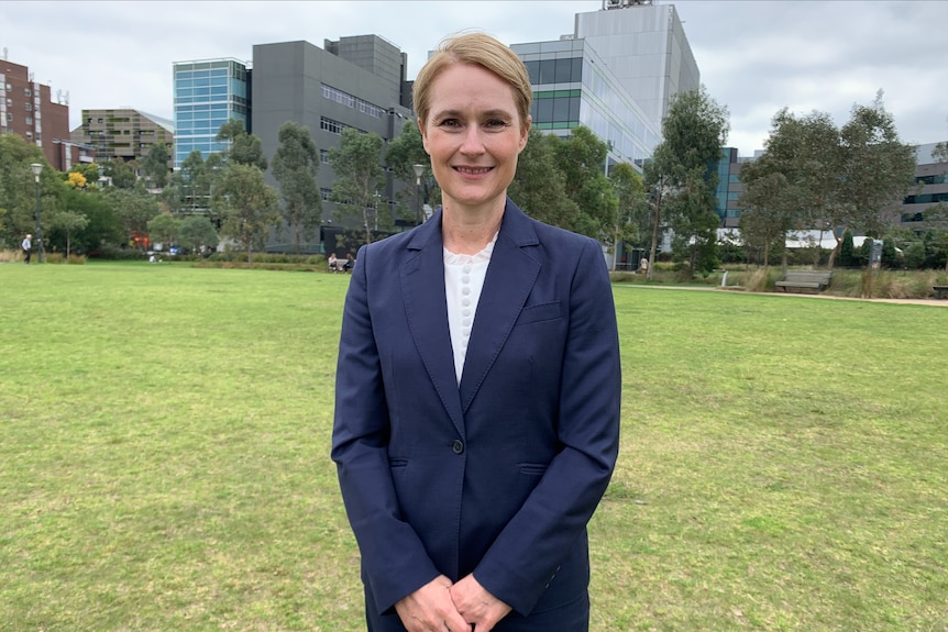 A woman with short blond hair wearing a suit.