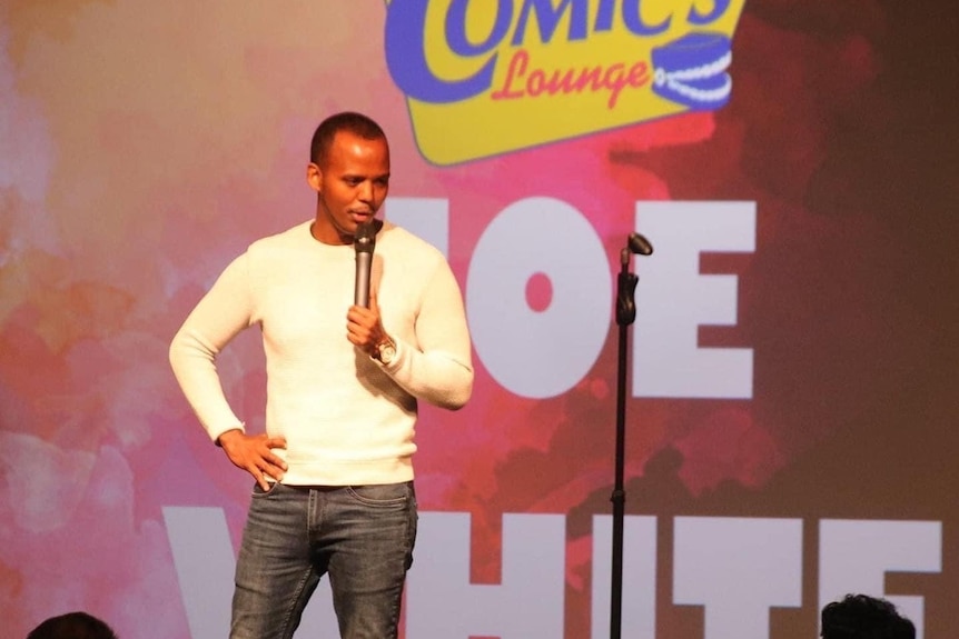 A photo of Joe White performing at the Comic's lounge.