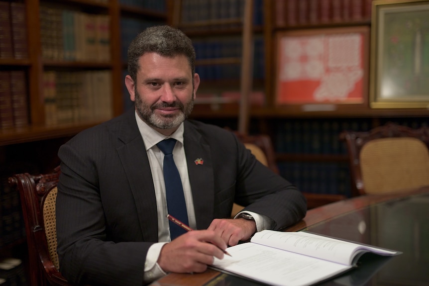 An MP sits down at a desk.