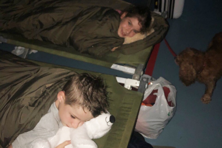 Children lay on camp beds at a house in flooded Townsville.