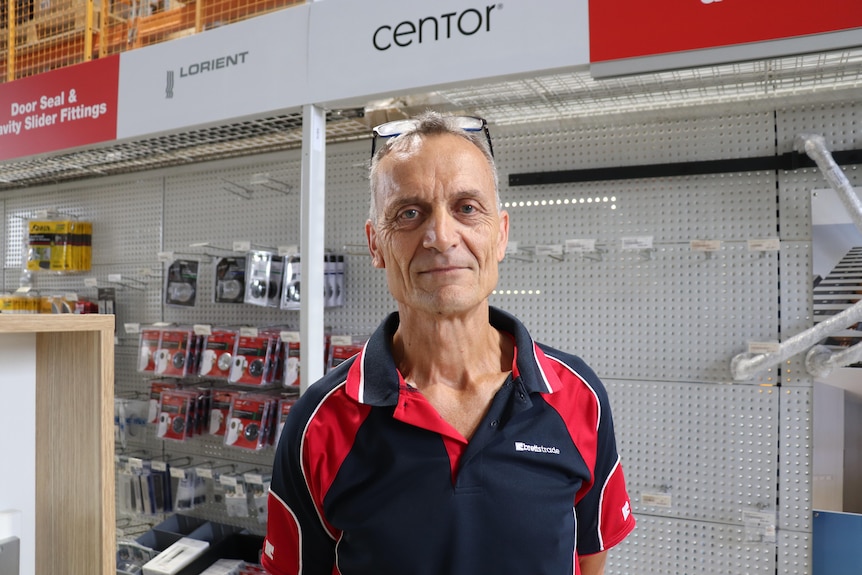 Paul stands in front of a rack.