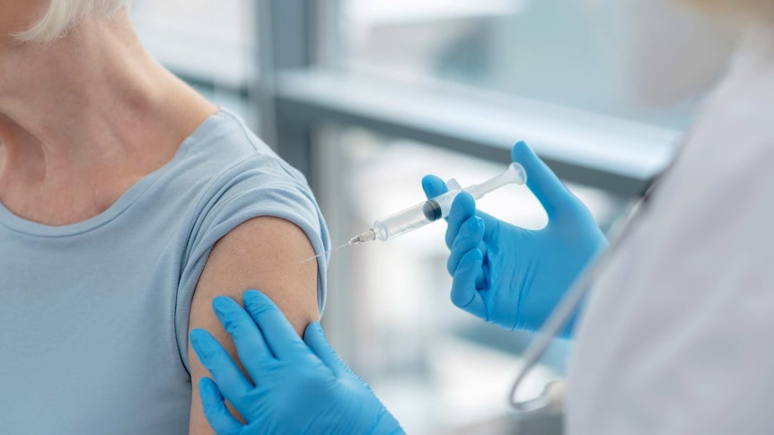 Close up picture of nurses hands holding a syringe before vaccination