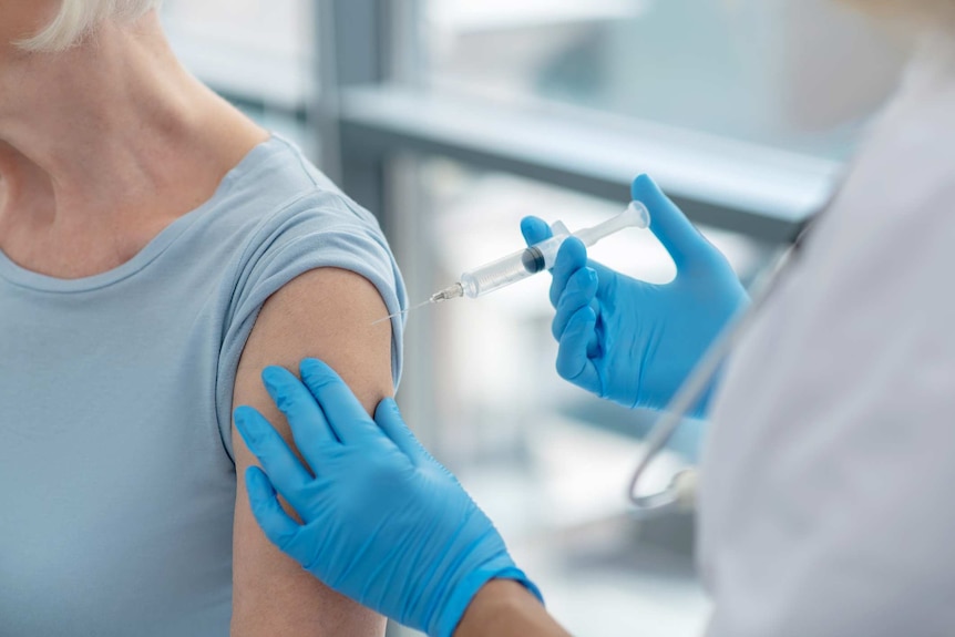 Close up picture of nurses hands holding a syringe before vaccination