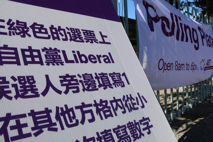 A close-up photograph of a poster with Chinese characters and the word 'Liberal', in a purple and white colour scheme.