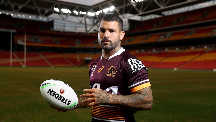 Adam Reynolds poses in a Broncos jersey 