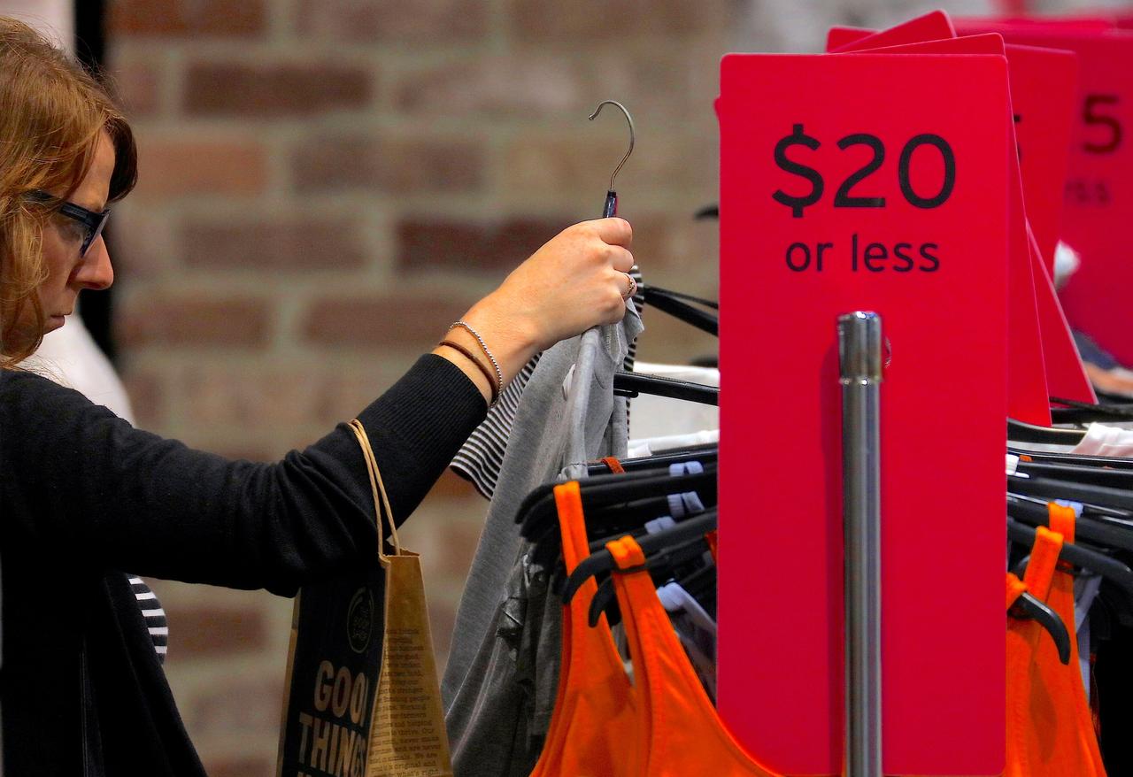 A shopper looks at clothes on sale