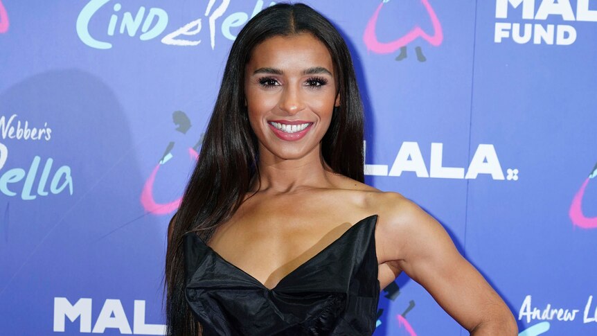Melody Thornton poses in a black dress on the red carpet of an event in 2021