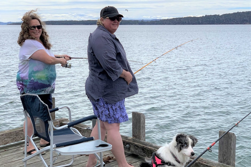 Two women fishing from a jetty.