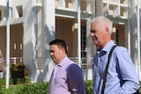 Lawyer Anthony Elliot and former commissioner John McRoberts walking outside