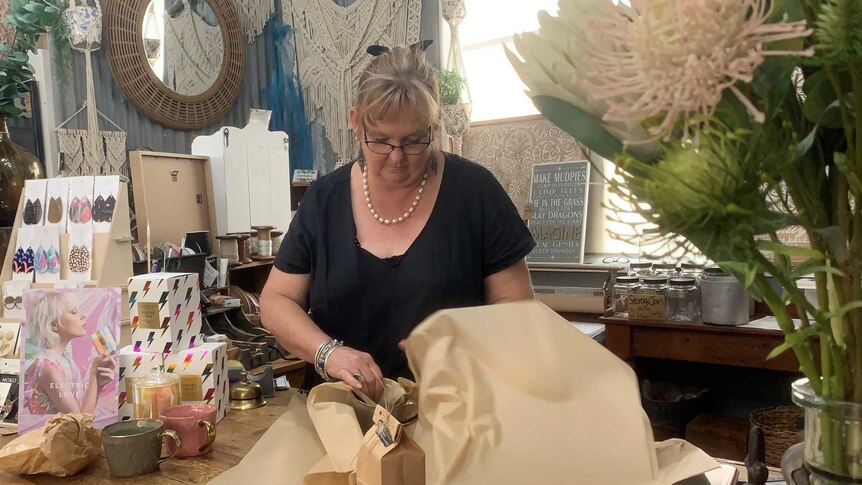 Debra Burt wrapping an item in her decor shop in Tallangatta.