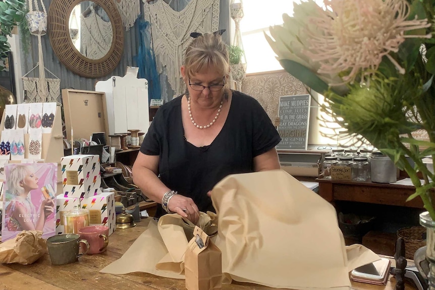 Debra Burt wrapping an item in her decor shop in Tallangatta.