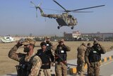 Soldiers holds their caps as a helicopter flies past during an operation near Bacha Khan University in Pakistan.