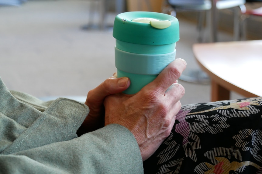 A woman's hands around a coffee mug.
