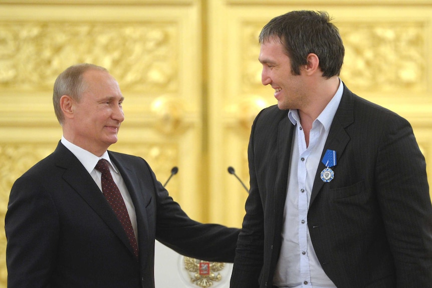 Vladimir Putin puts an affectionate hand on Alexander Ovechkin's arm