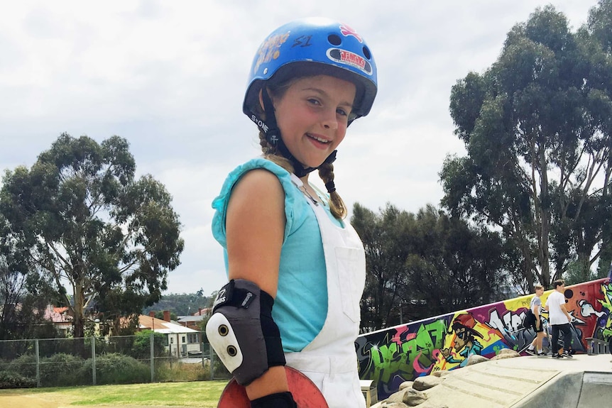 Anneka Lewis 10 year old skater with her board at a skate park,