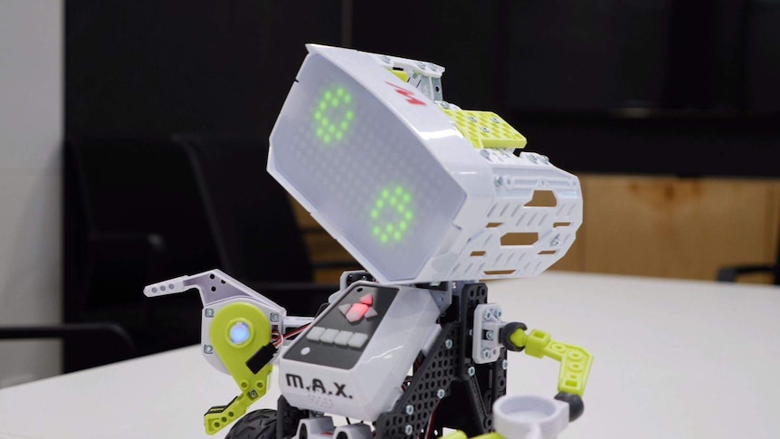 A light grey robot tilting its head. It has pixelated green eyes and claw like hands